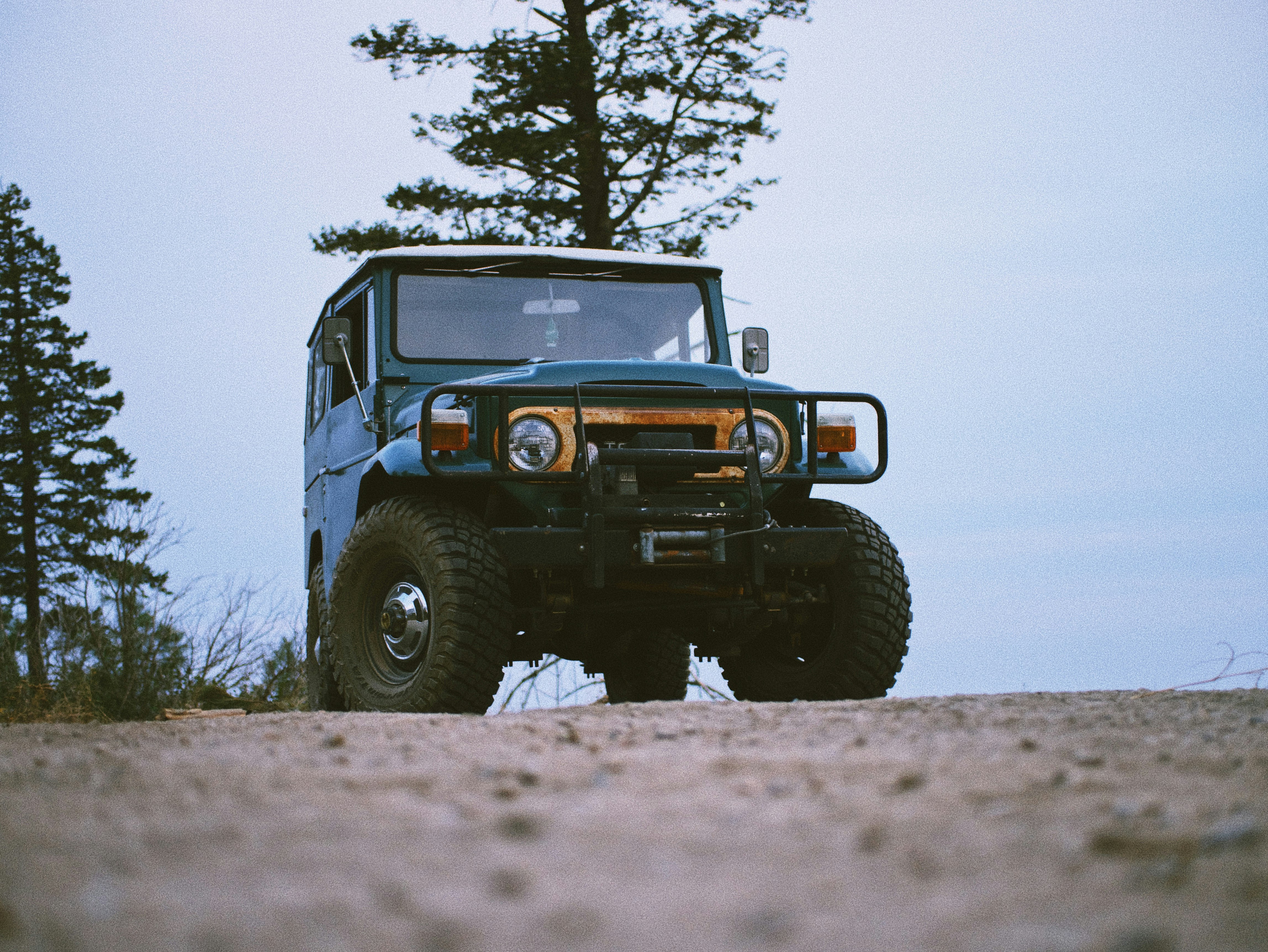 blue and black jeep wrangler on brown field during daytime